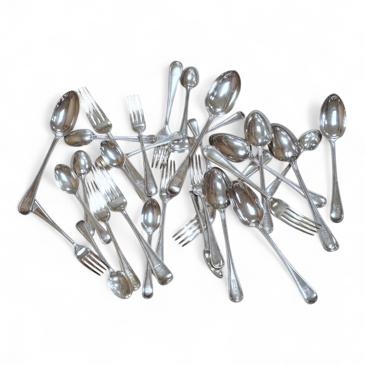 A harlequin part canteen of late Victorian and Edwardian silver beaded Old English pattern flatware, various dates and makers, comprising thirty items, 55.8oz.